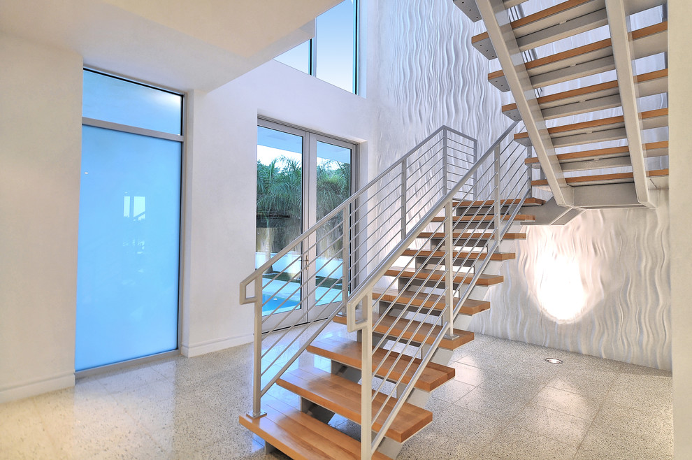 Foto de escalera suspendida minimalista grande sin contrahuella con escalones de madera y barandilla de metal
