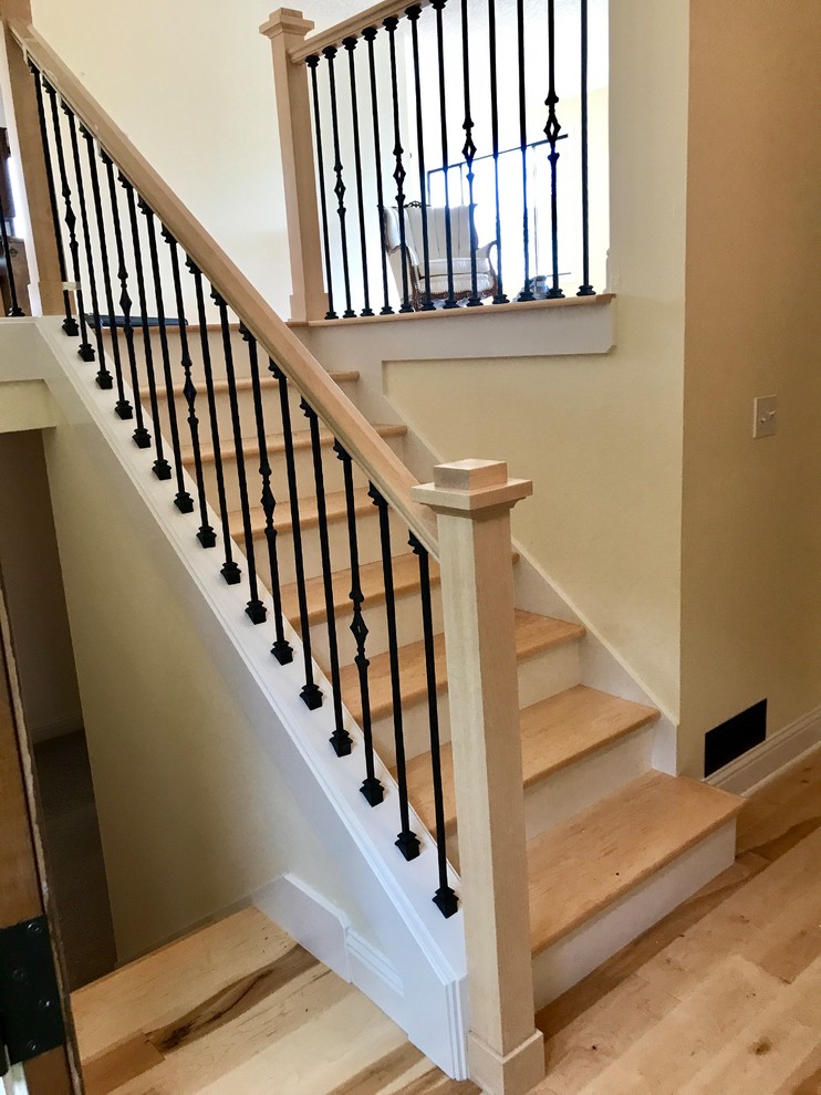 Diseño de escalera recta de estilo americano de tamaño medio con escalones de madera, contrahuellas de madera pintada y barandilla de madera