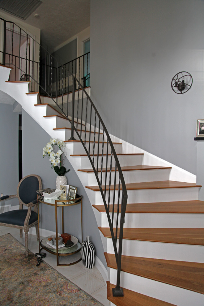 Идея дизайна: изогнутая деревянная лестница среднего размера в классическом стиле с деревянными ступенями и металлическими перилами