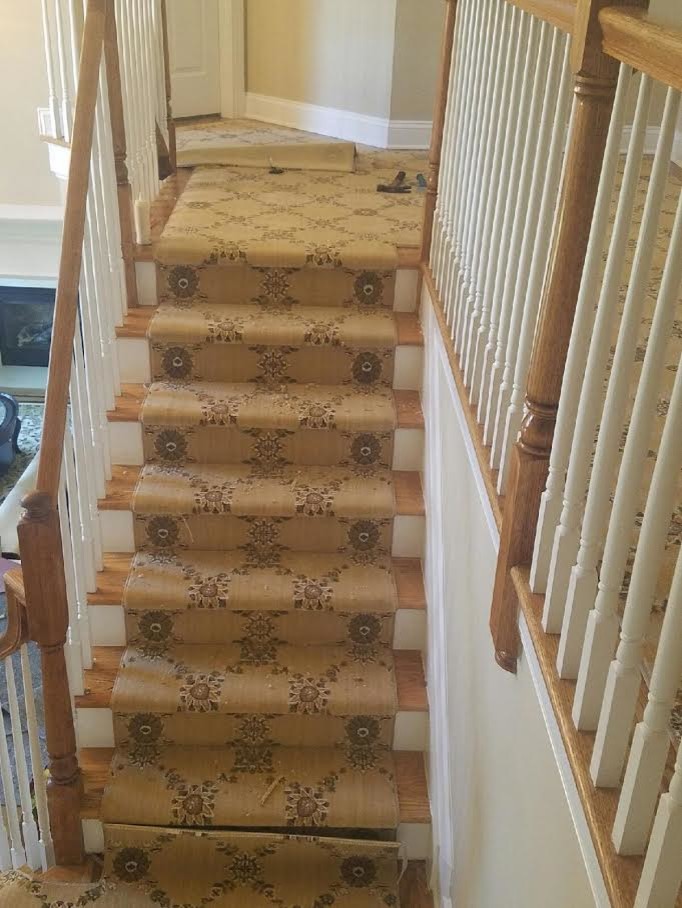 Imagen de escalera en L clásica grande con escalones de madera y contrahuellas de madera pintada