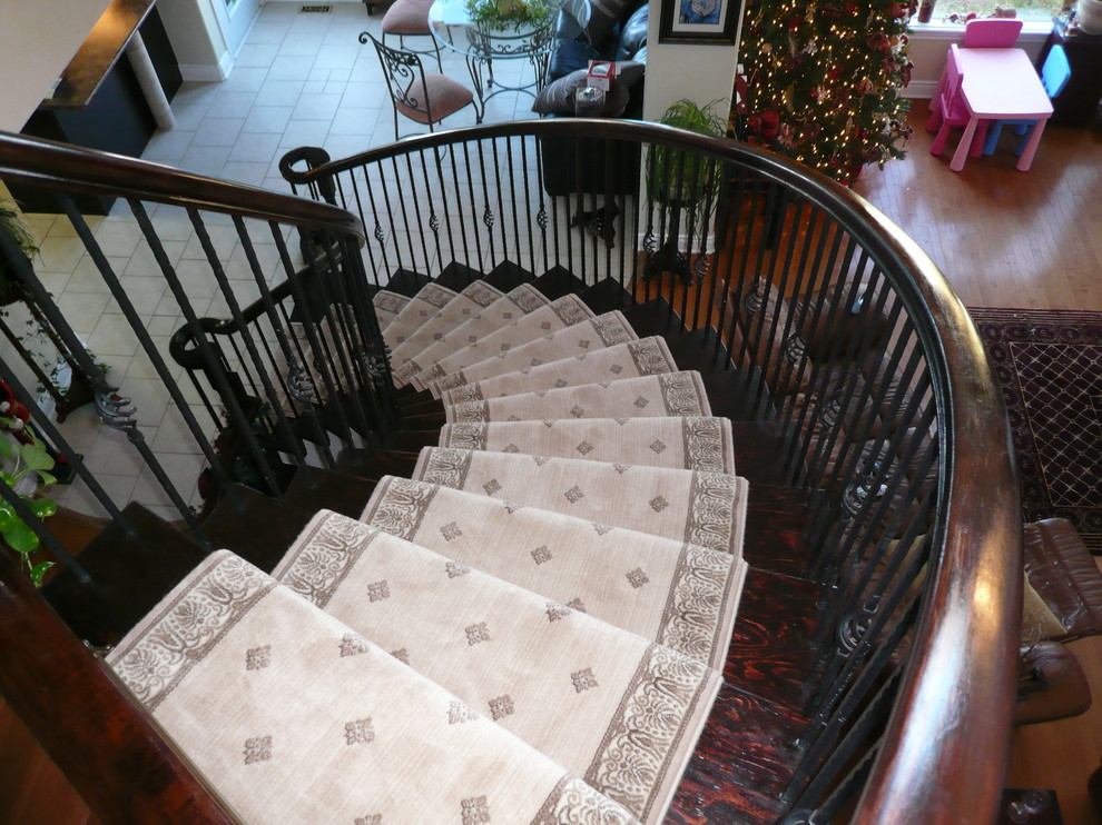 Idée de décoration pour un escalier courbe tradition de taille moyenne avec des marches en bois et des contremarches en bois.
