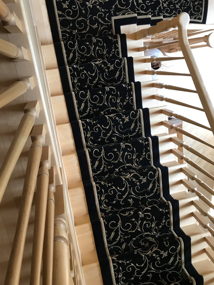 Cette image montre un escalier traditionnel en L de taille moyenne avec des marches en moquette, des contremarches en moquette et un garde-corps en bois.