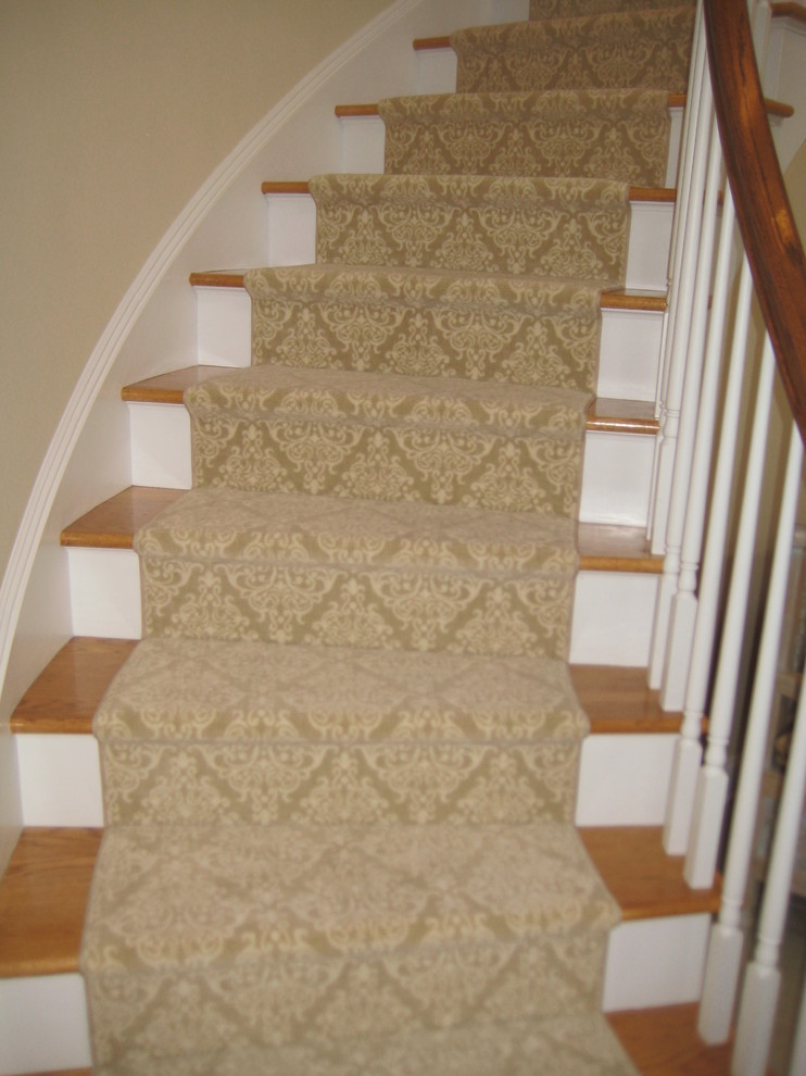 Imagen de escalera curva clásica de tamaño medio con escalones de madera y contrahuellas de madera pintada