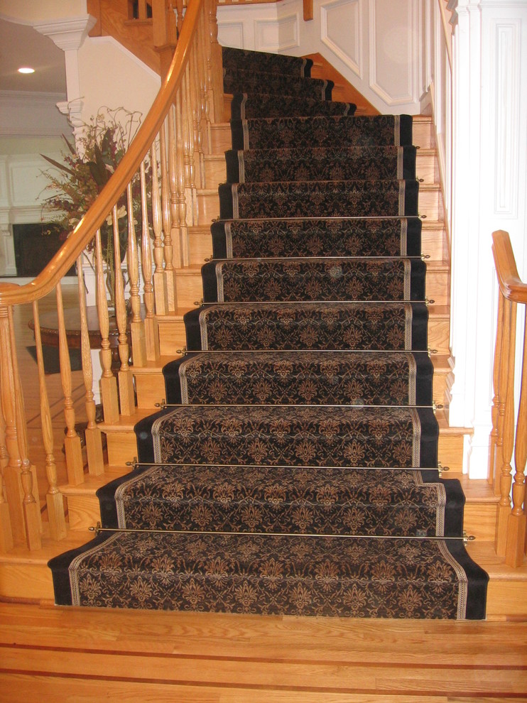Ejemplo de escalera curva tradicional de tamaño medio con escalones de madera y contrahuellas de madera