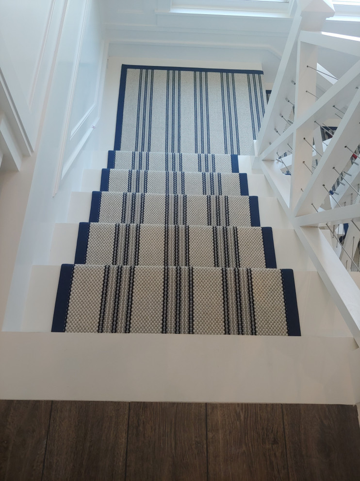 Idées déco pour un escalier peint bord de mer en U de taille moyenne avec des marches en bois peint et un garde-corps en bois.