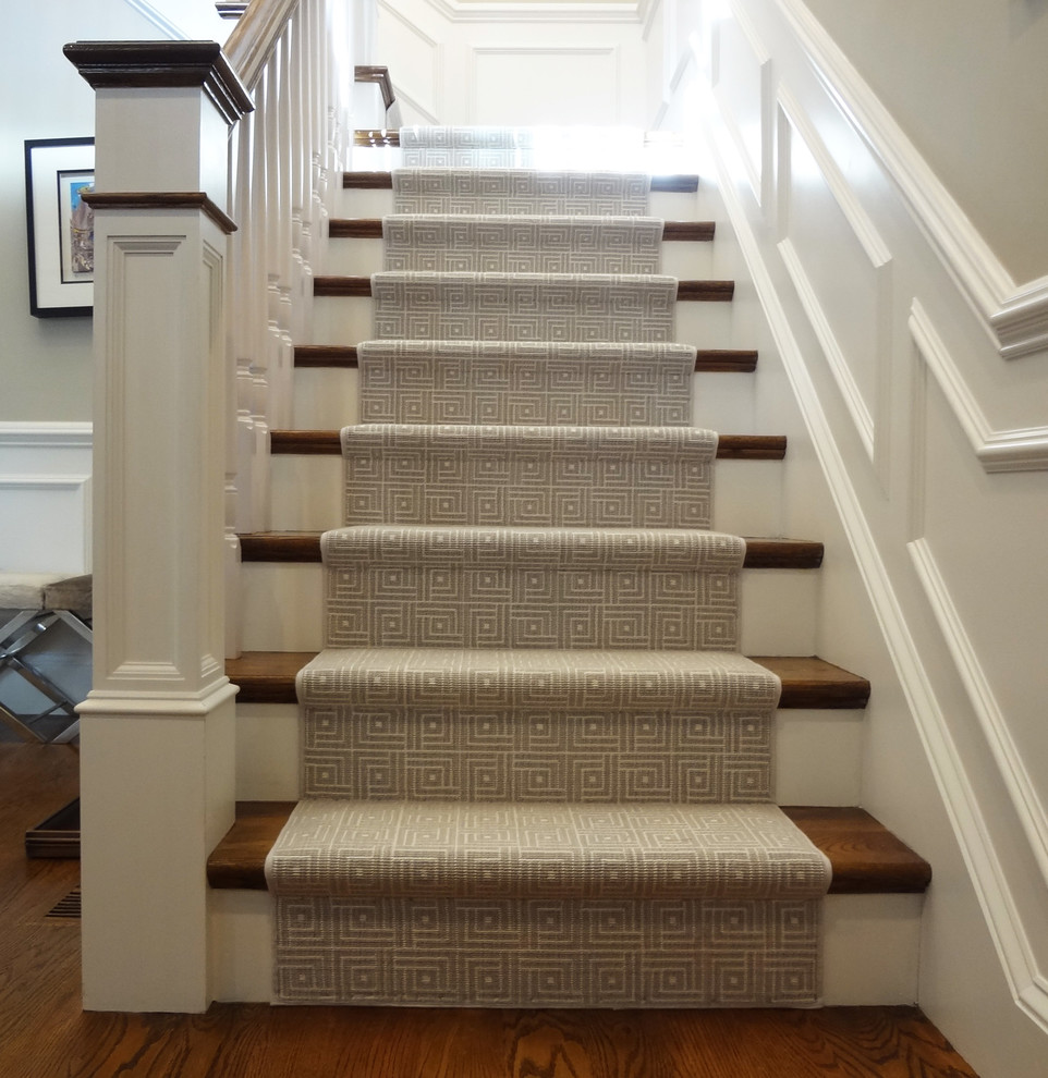 Idée de décoration pour un grand escalier tradition en L avec des marches en moquette et des contremarches en moquette.