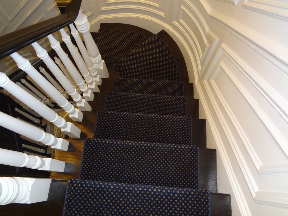 Пример оригинального дизайна: большая угловая лестница в стиле неоклассика (современная классика) с ступенями с ковровым покрытием и ковровыми подступенками