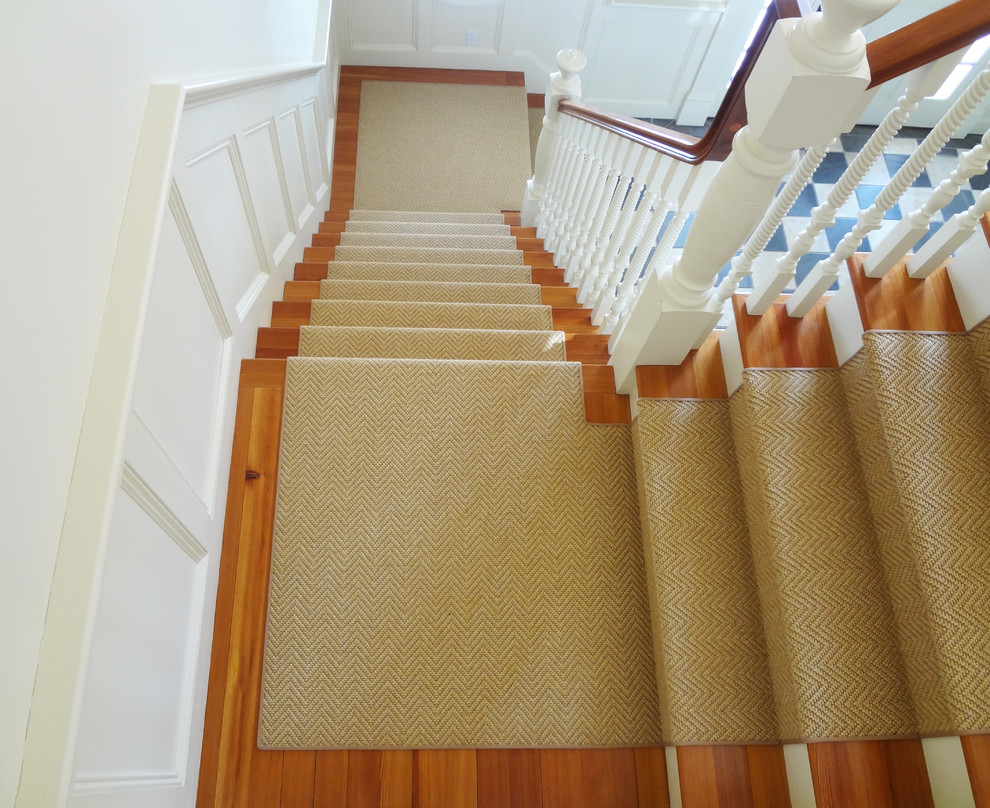 На фото: большая угловая лестница в стиле неоклассика (современная классика) с ступенями с ковровым покрытием и ковровыми подступенками