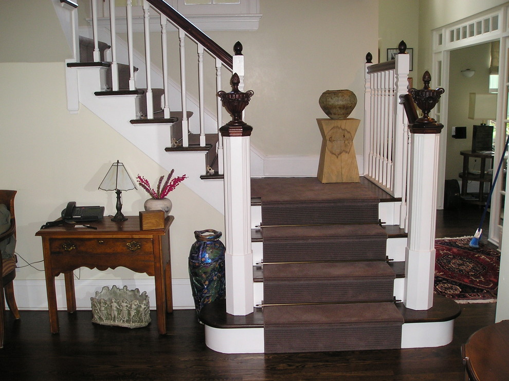 Imagen de escalera en L clásica de tamaño medio con escalones de madera y contrahuellas de madera pintada
