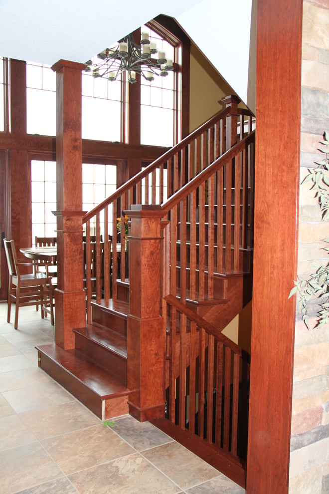 Ejemplo de escalera en U de estilo americano grande con escalones de madera y contrahuellas de madera