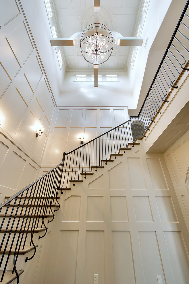 Cette image montre un grand escalier peint traditionnel en L avec des marches en bois et un garde-corps en métal.