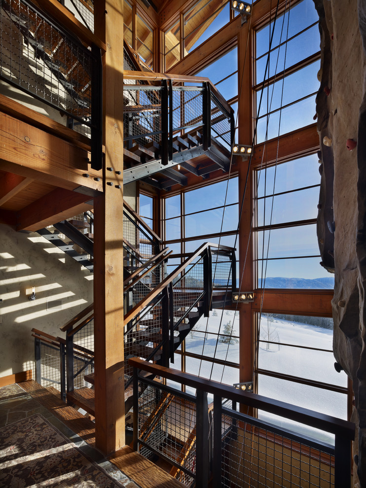 Aménagement d'un grand escalier sans contremarche industriel en U avec des marches en bois, un garde-corps en matériaux mixtes et palier.