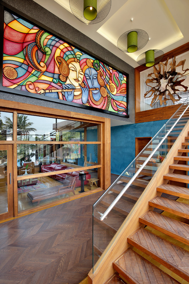 На фото: прямая лестница в стиле фьюжн с деревянными ступенями и стеклянными перилами