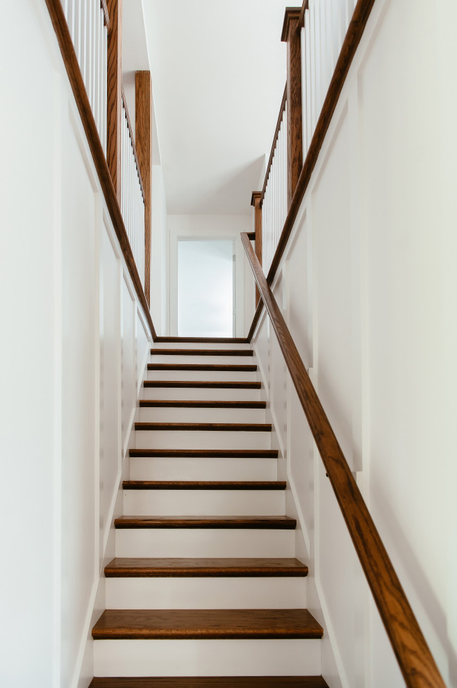 Diseño de escalera recta clásica pequeña con escalones de madera, contrahuellas de madera pintada y barandilla de madera
