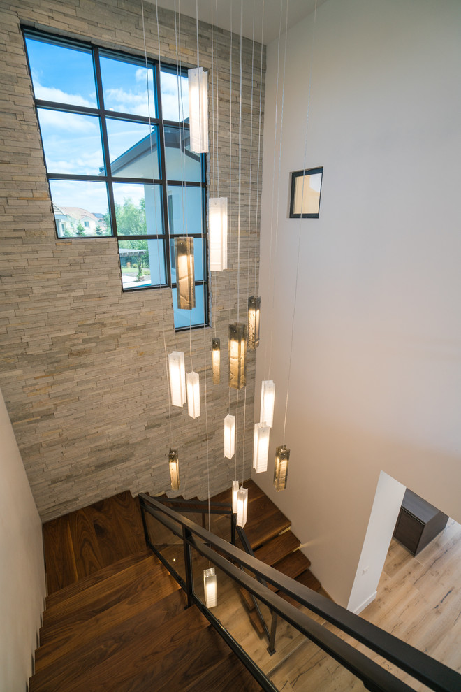 Источник вдохновения для домашнего уюта: большая металлическая лестница на больцах в современном стиле с деревянными ступенями и стеклянными перилами