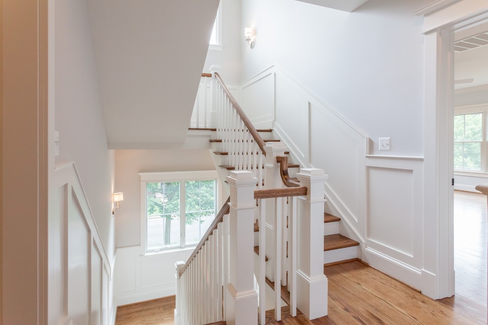 Inspiration for a country wood u-shaped wood railing staircase in DC Metro with painted wood risers.