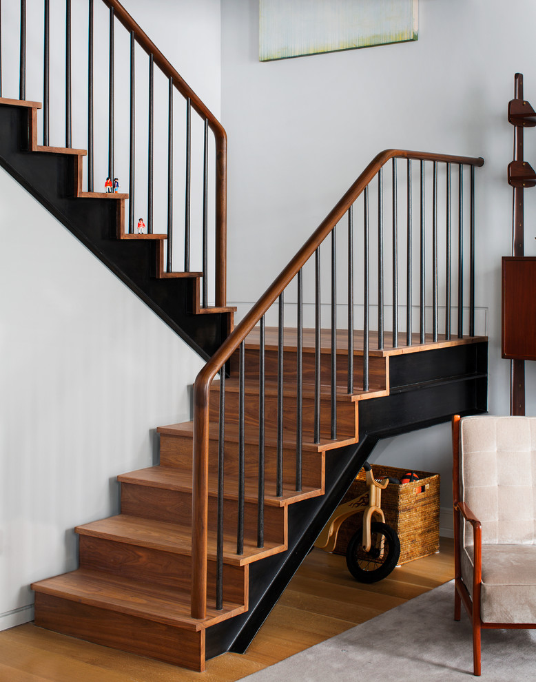 Inspiration for a contemporary wood staircase spindle in New York with under stair storage.