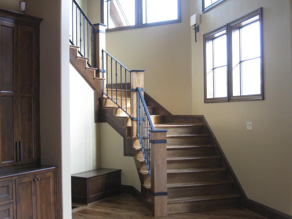 Стильный дизайн: большая изогнутая деревянная лестница в стиле рустика с деревянными ступенями - последний тренд