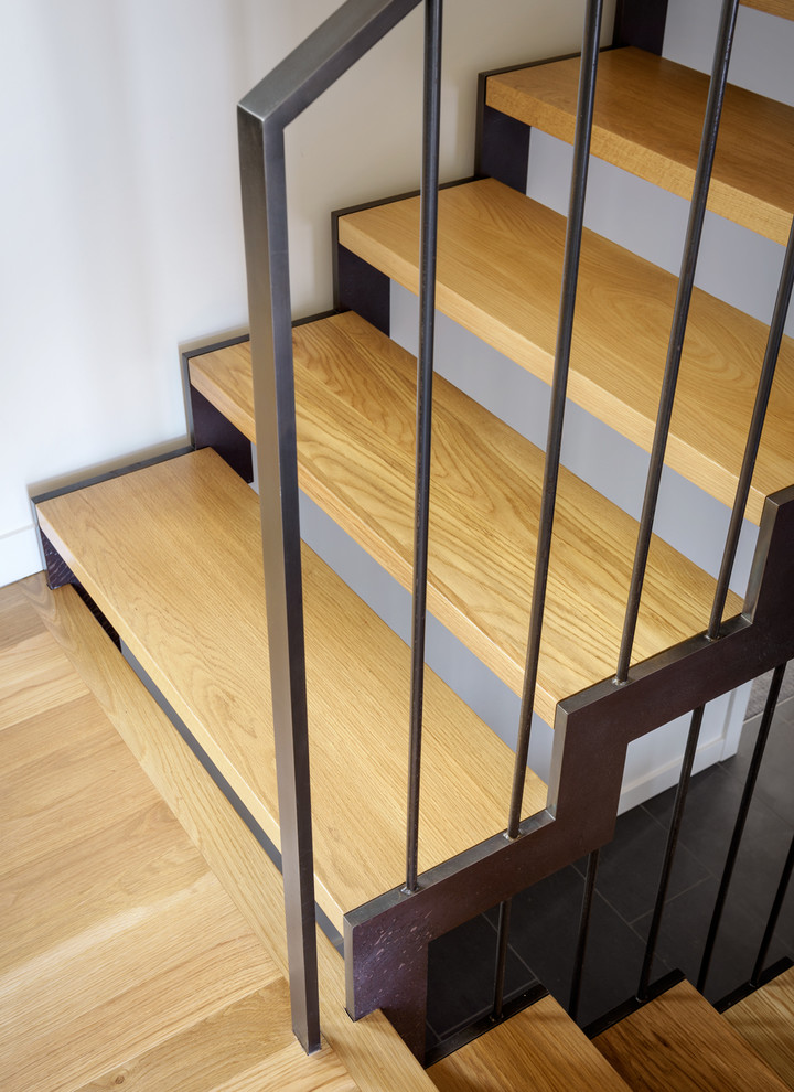 Imagen de escalera en U moderna de tamaño medio con escalones de madera, contrahuellas de metal y barandilla de metal