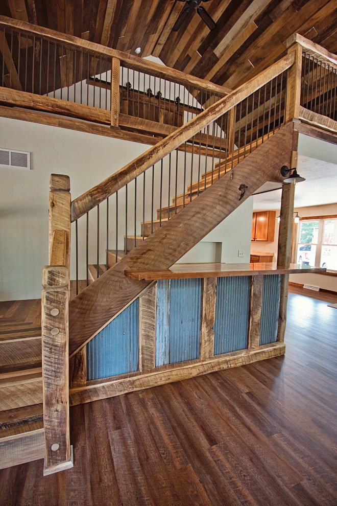 Diseño de escalera en L rural grande con escalones de madera, contrahuellas de metal y barandilla de madera