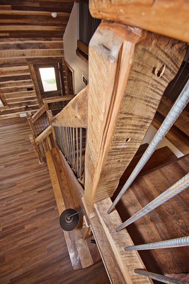 Cette photo montre un grand escalier montagne en L avec des marches en bois, des contremarches en métal et un garde-corps en bois.