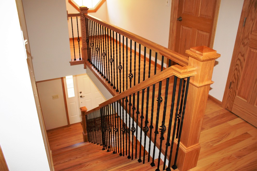 Diseño de escalera recta tradicional con escalones de madera, contrahuellas de madera pintada y barandilla de varios materiales