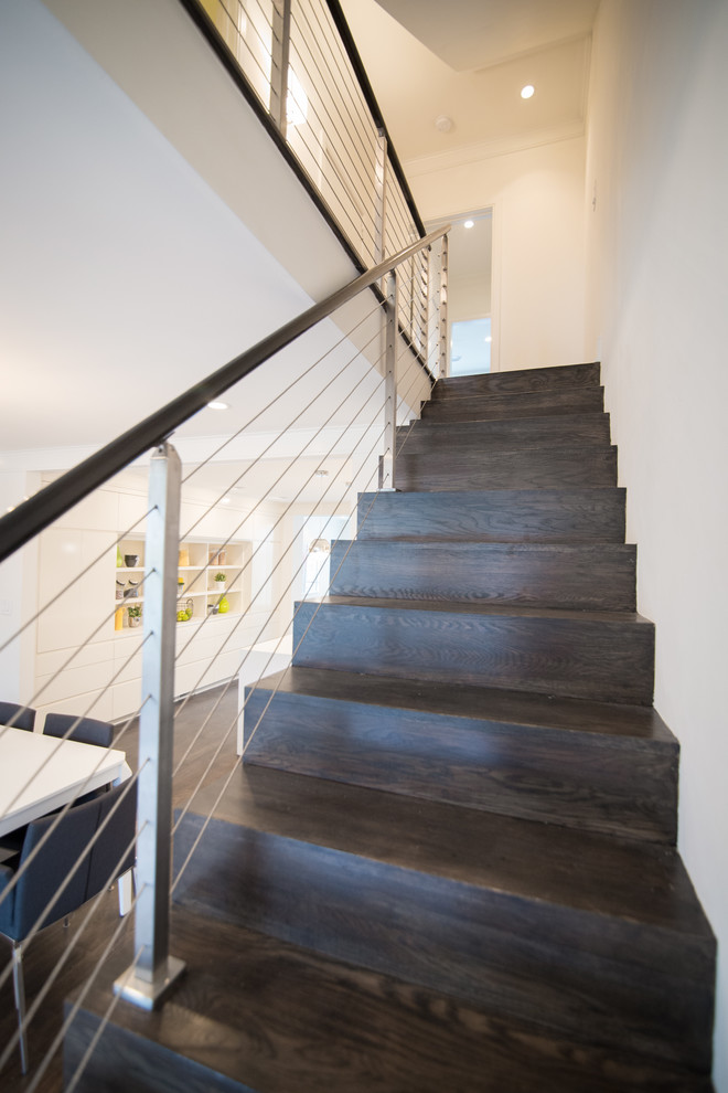 Diseño de escalera recta minimalista de tamaño medio con escalones de madera, contrahuellas de madera y barandilla de cable