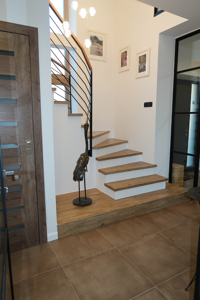 Diseño de escalera en U industrial pequeña con escalones de madera, contrahuellas de hormigón y barandilla de metal