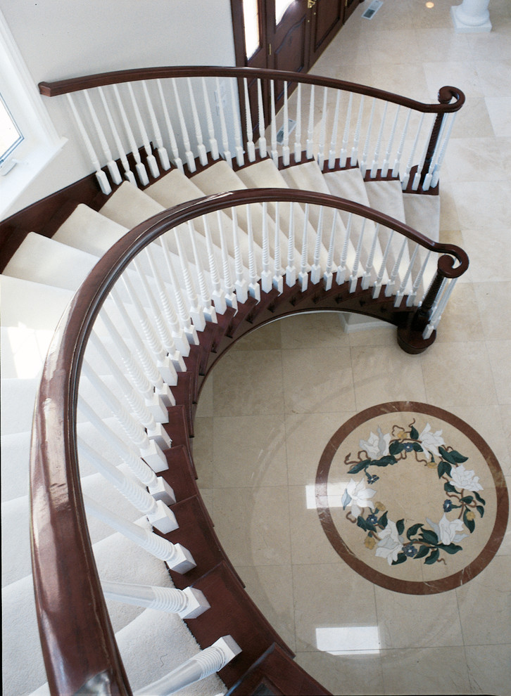 Idée de décoration pour un grand escalier courbe tradition avec des marches en bois.