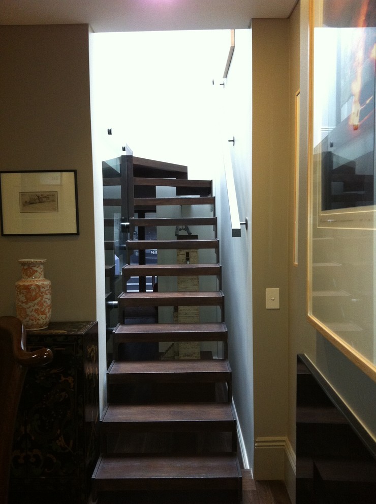 Cette image montre un petit escalier flottant urbain avec des marches en bois et des contremarches en métal.