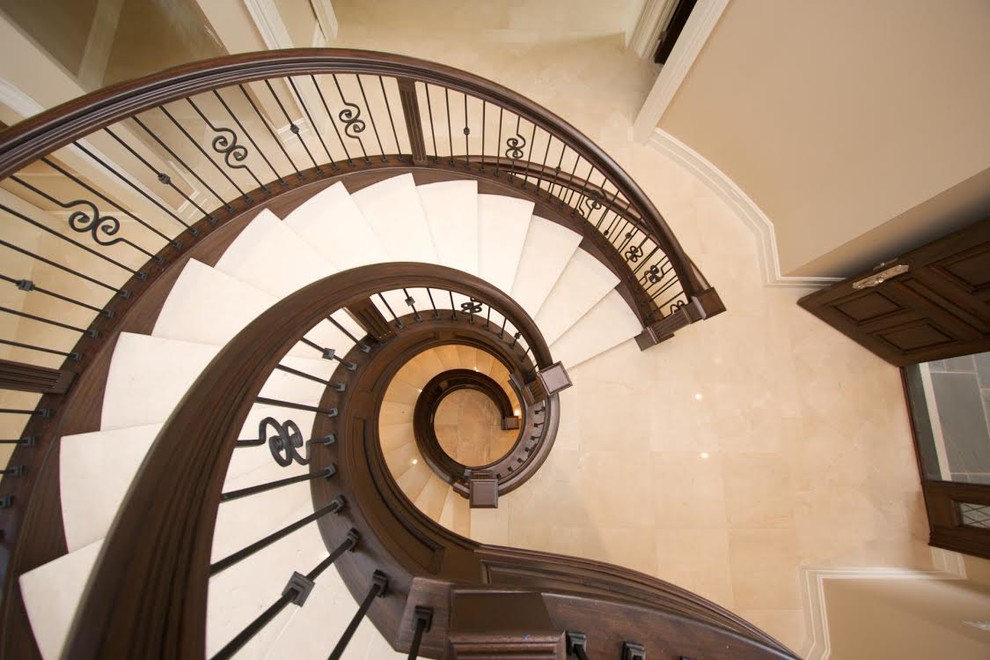 Пример оригинального дизайна: винтовая лестница в викторианском стиле с ступенями с ковровым покрытием, ковровыми подступенками и деревянными перилами