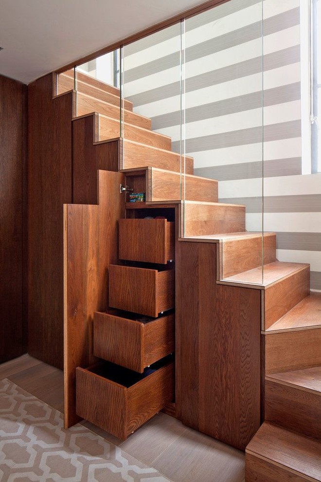 На фото: угловая деревянная лестница в современном стиле с деревянными ступенями и кладовкой или шкафом под ней с