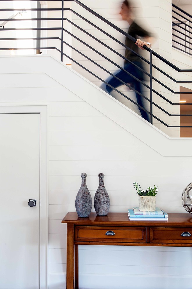 Large trendy wooden u-shaped staircase photo in Orange County with wooden risers