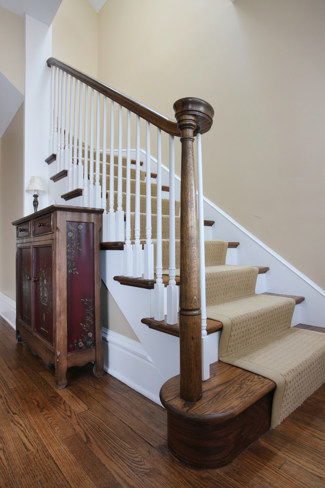 Example of a mid-sized classic carpeted curved staircase design in Chicago with painted risers