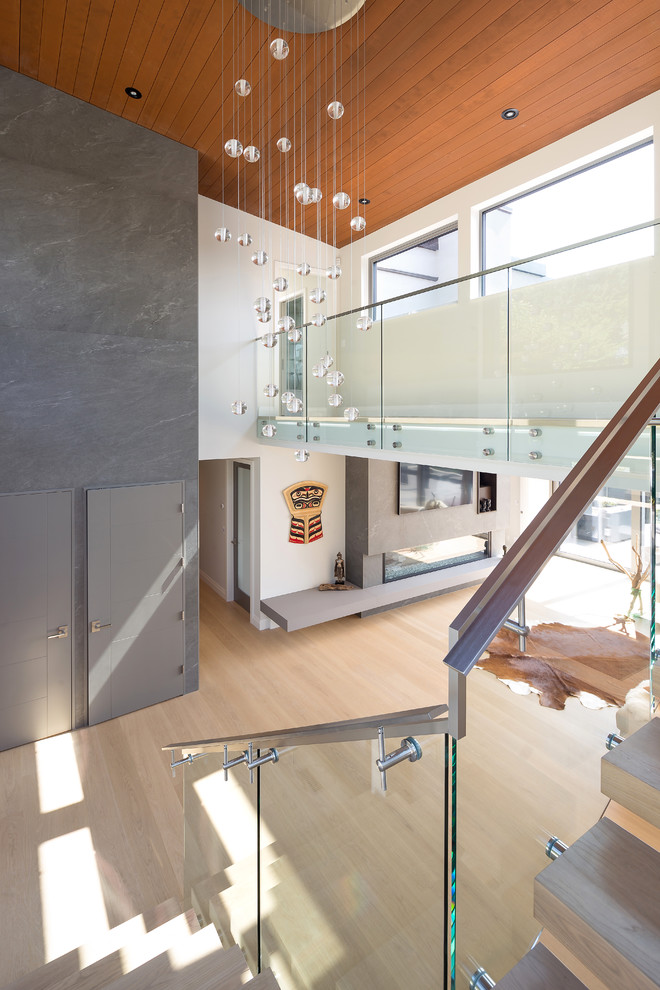 Imagen de escalera contemporánea con contrahuellas de vidrio y barandilla de metal