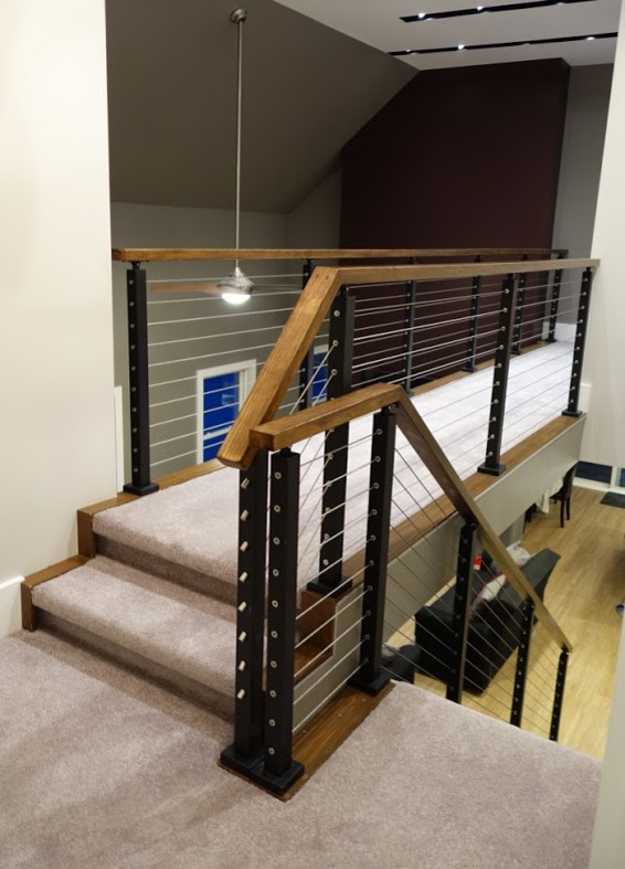 Idée de décoration pour un escalier droit design de taille moyenne avec des marches en moquette, des contremarches en moquette et un garde-corps en bois.