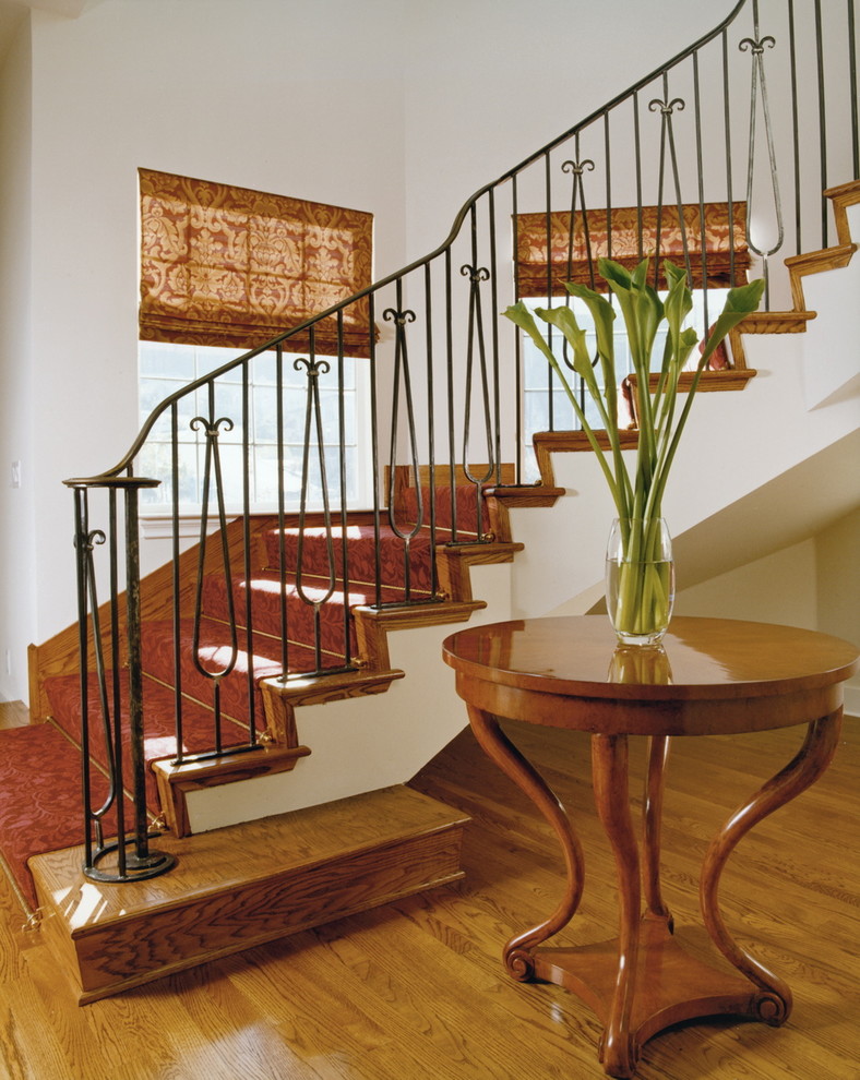 Diseño de escalera curva clásica con escalones de madera y contrahuellas de madera