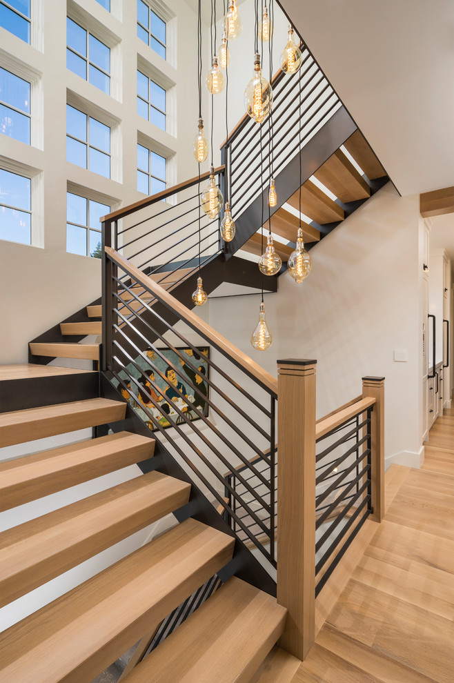 Cette image montre un escalier sans contremarche flottant design de taille moyenne avec des marches en bois et un garde-corps en matériaux mixtes.