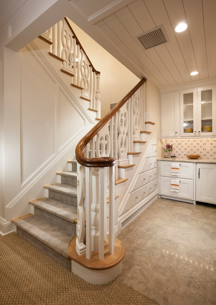 На фото: п-образная лестница среднего размера в классическом стиле с деревянными ступенями, деревянными перилами, крашенными деревянными подступенками и кладовкой или шкафом под ней