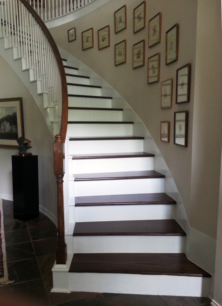 Idées déco pour un grand escalier courbe classique avec des marches en bois, des contremarches en bois et un garde-corps en bois.