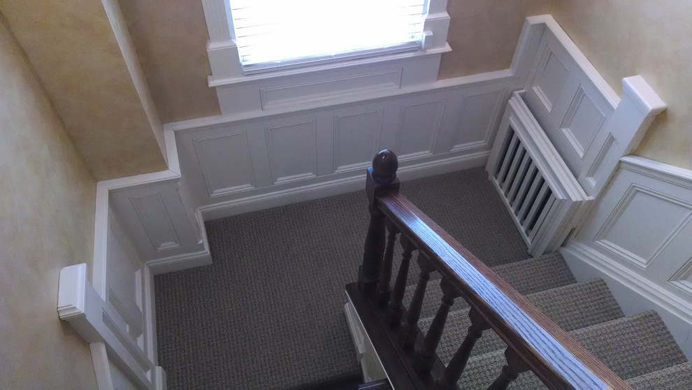 Example of a mid-sized classic carpeted u-shaped wood railing staircase design in New York with carpeted risers