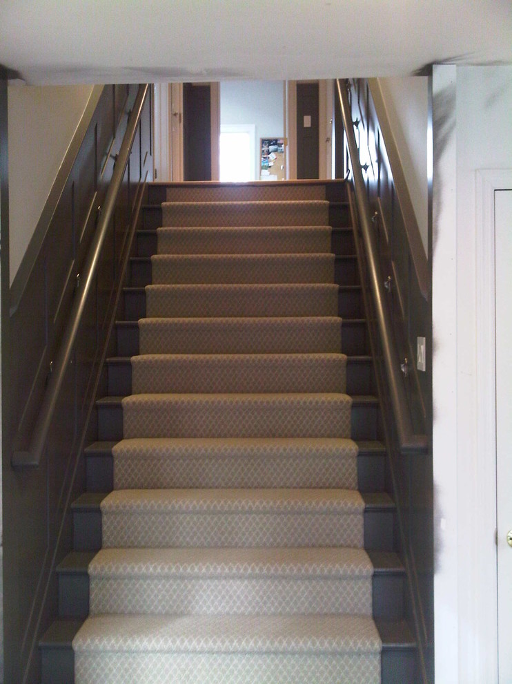 ニューヨークにあるお手頃価格の小さなトラディショナルスタイルのおしゃれな直階段 (フローリングの蹴込み板、木材の手すり) の写真