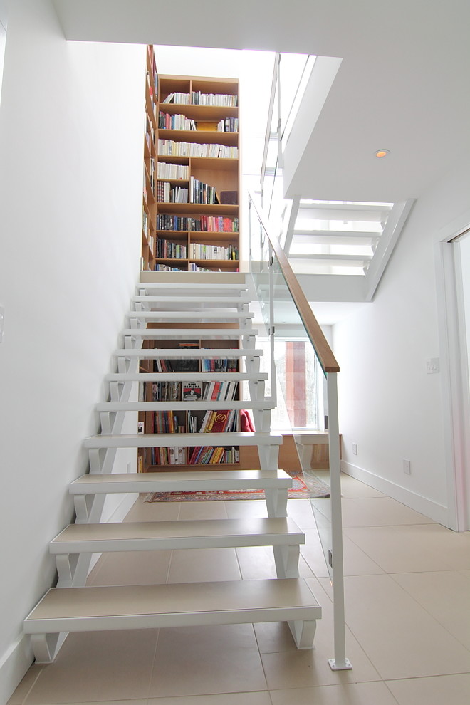 На фото: маленькая п-образная лестница в стиле модернизм с деревянными ступенями и кладовкой или шкафом под ней для на участке и в саду с