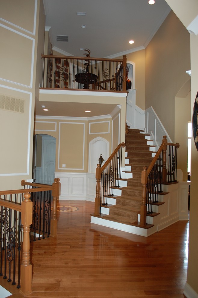 Cette photo montre un escalier courbe chic de taille moyenne avec des marches en moquette et des contremarches en bois.