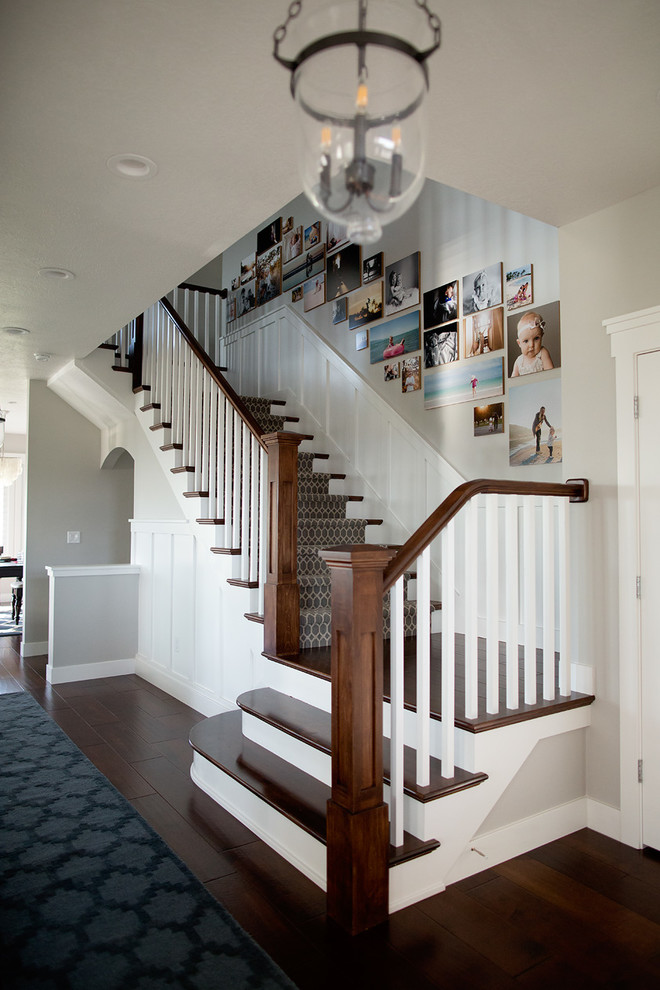 Стильный дизайн: большая п-образная лестница в стиле кантри с деревянными ступенями и ковровыми подступенками - последний тренд