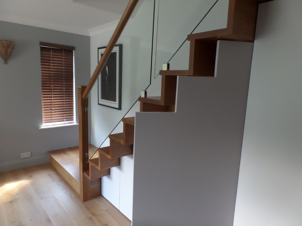 Exemple d'un escalier droit tendance de taille moyenne avec des marches en bois, des contremarches en bois et un garde-corps en verre.