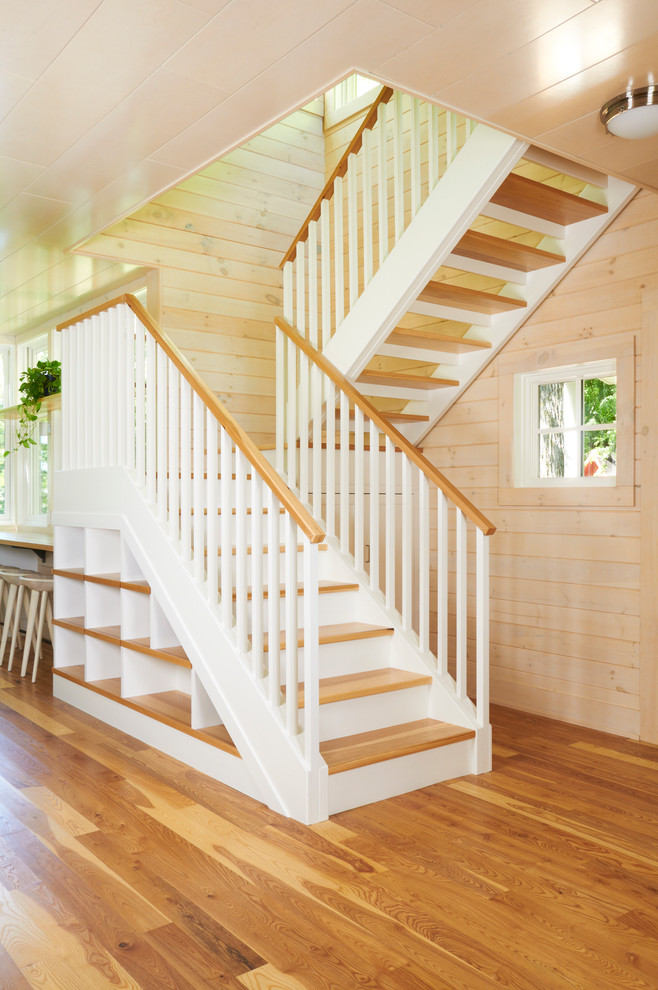 На фото: угловая лестница среднего размера в классическом стиле с деревянными ступенями и крашенными деревянными подступенками с