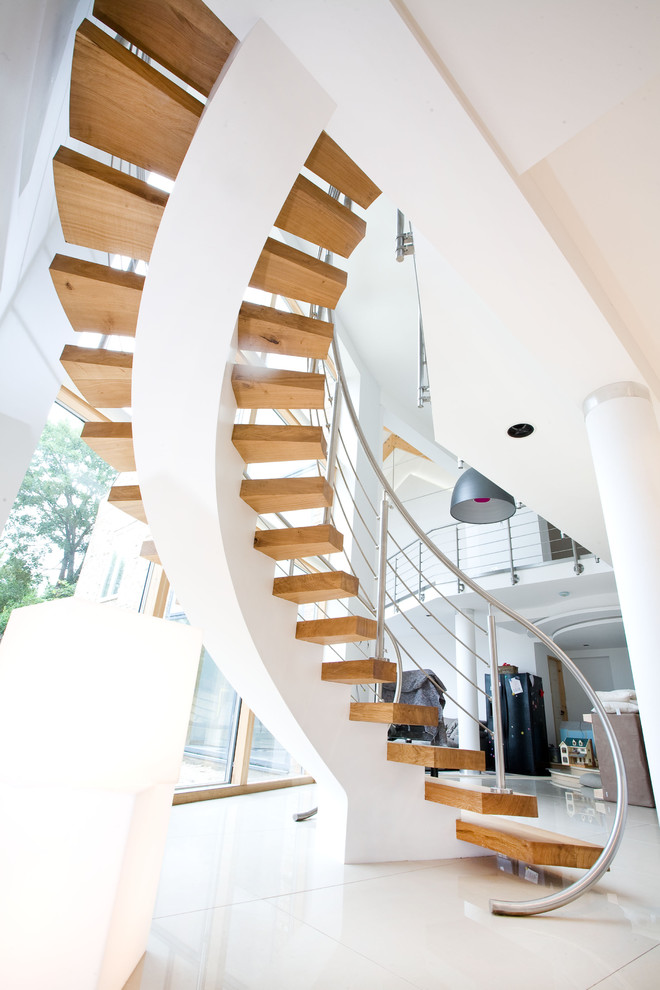 Inspiration for a contemporary curved open staircase remodel in London