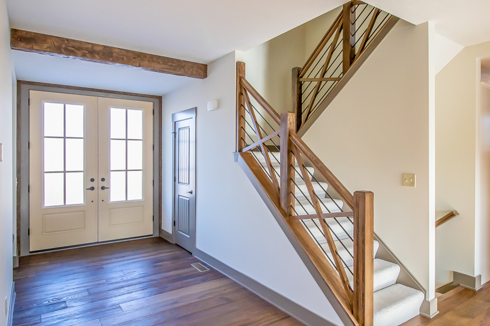 Ejemplo de escalera de estilo de casa de campo grande con escalones enmoquetados, contrahuellas enmoquetadas y barandilla de varios materiales