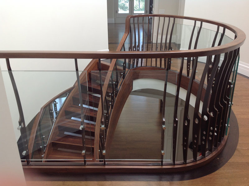 Imagen de escalera curva contemporánea de tamaño medio sin contrahuella con escalones de madera y barandilla de varios materiales